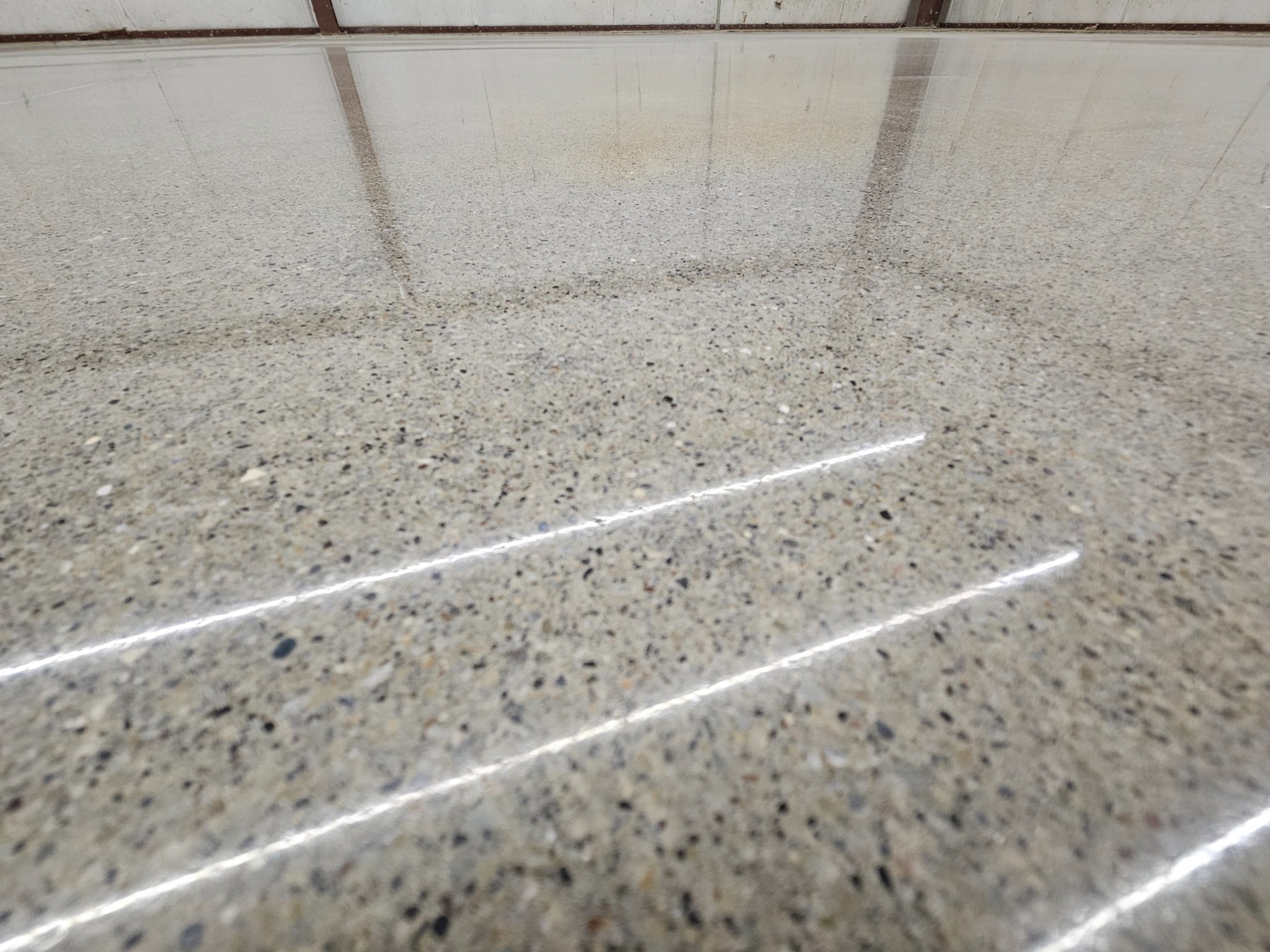 Wide view of polished concrete floor in commercial warehouse by Northshore Specialty Surfaces